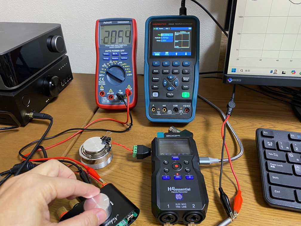 コンデンサを振動スピーカーにクリップで固定して振動させマイクロフォニック音の周波数特性を測定している写真