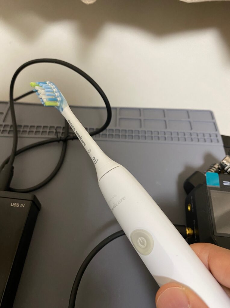 電磁波によるノイズ源として電動歯ブラシを使い、USBケーブルに近づけるようす